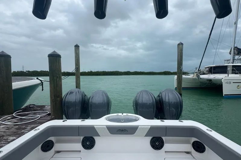  Yacht Photos Pics 2025 Invincible 35 Catamaran docked, featuring powerful outboard engines, on a cloudy day.