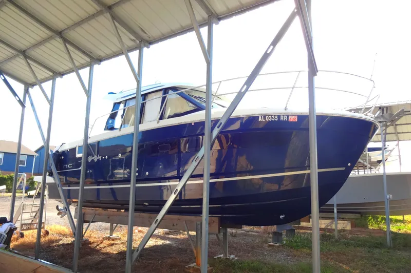 Blue Baby Yacht Photos Pics 2022 Jeanneau Merry Fisher 895 Offshore boat in dry dock under shelter.