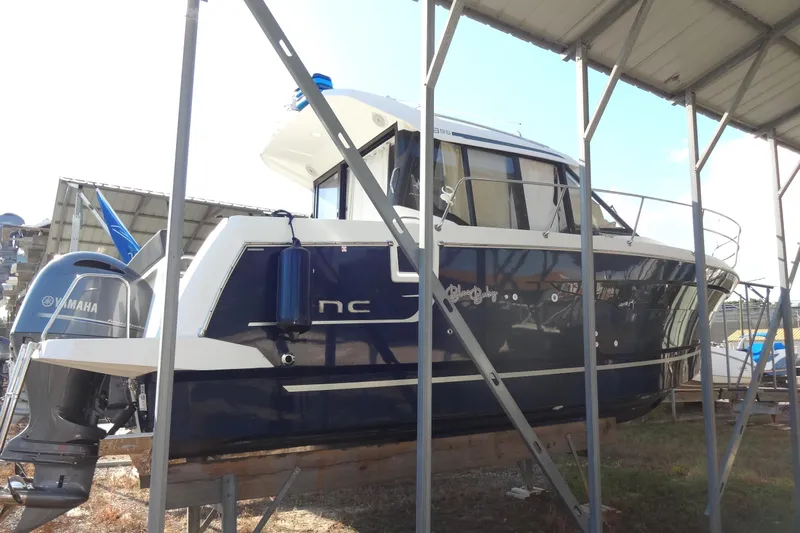 Blue Baby Yacht Photos Pics 2022 Jeanneau Merry Fisher 895 Offshore boat with Yamaha engine, docked under shelter.