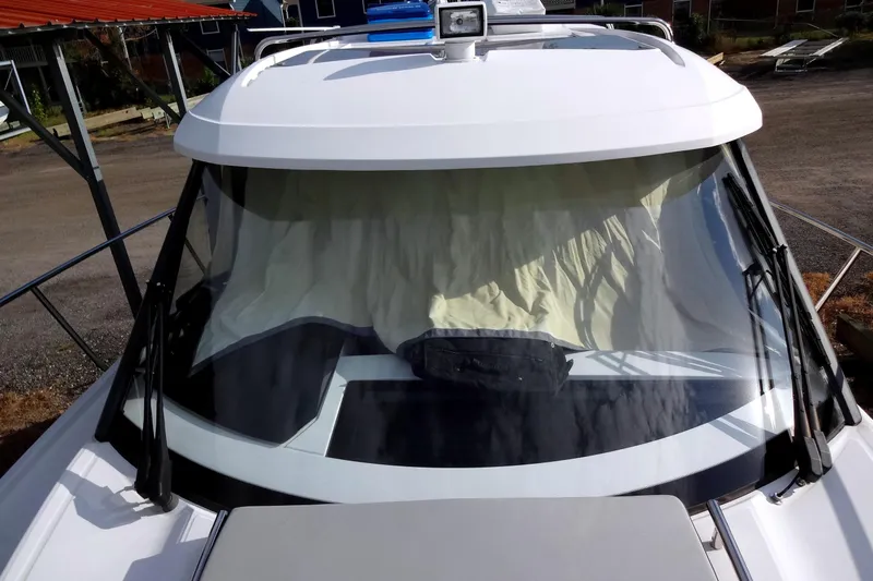 Blue Baby Yacht Photos Pics 2022 Jeanneau Merry Fisher 895 Offshore boat with covered windshield, docked outdoors.