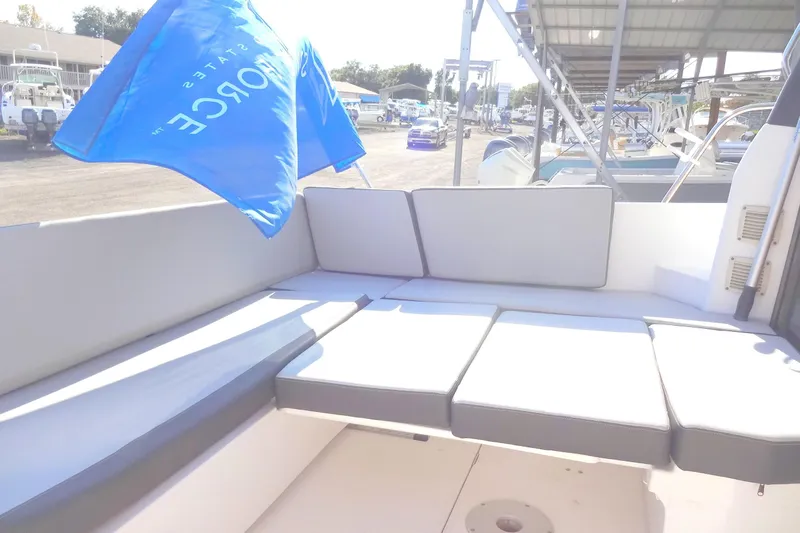 Blue Baby Yacht Photos Pics 2022 Jeanneau Merry Fisher 895 Offshore boat with cushioned seating and blue flag.