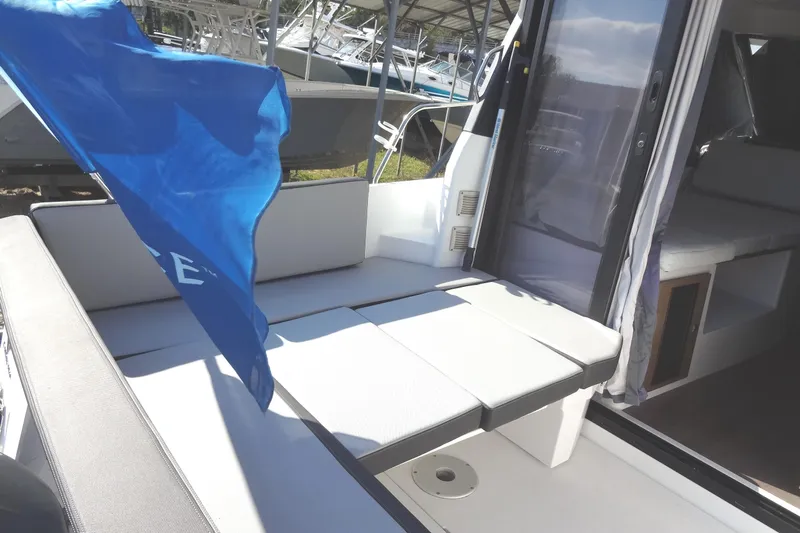 Blue Baby Yacht Photos Pics 2022 Jeanneau Merry Fisher 895 Offshore boat interior with seating and blue flag.