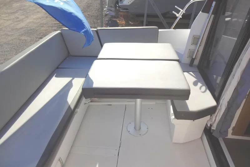 Blue Baby Yacht Photos Pics 2022 Jeanneau Merry Fisher 895 Offshore boat deck with cushioned seating and table.