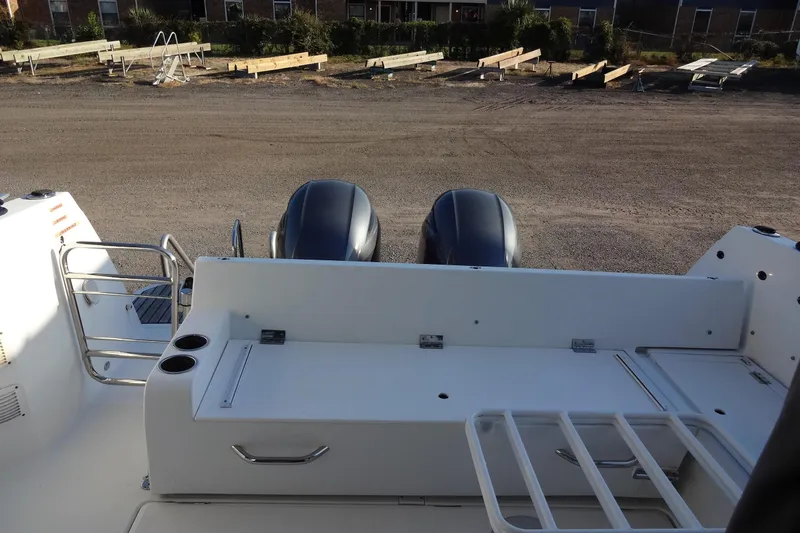 Blue Baby Yacht Photos Pics 2022 Jeanneau Merry Fisher 895 Offshore boat with dual outboard motors, docked on gravel.