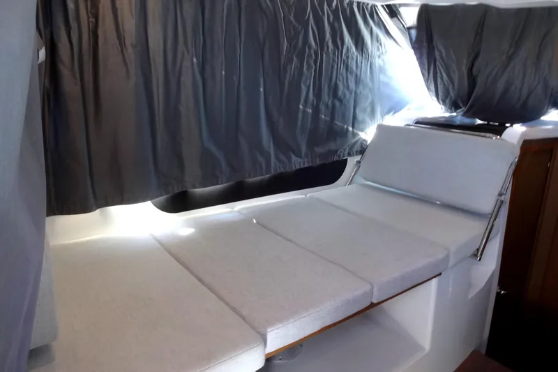 Blue Baby Yacht Photos Pics Interior of 2022 Jeanneau Merry Fisher 895 Offshore with cushioned seating and curtains.