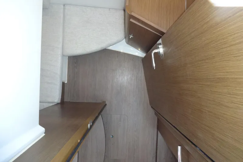 Blue Baby Yacht Photos Pics Interior of 2022 Jeanneau Merry Fisher 895 Offshore, featuring wood cabinetry and seating.
