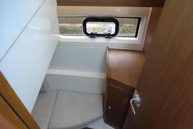 Blue Baby Yacht Photos Pics Interior cabin of 2022 Jeanneau Merry Fisher 895 Offshore, featuring wood finish and window.