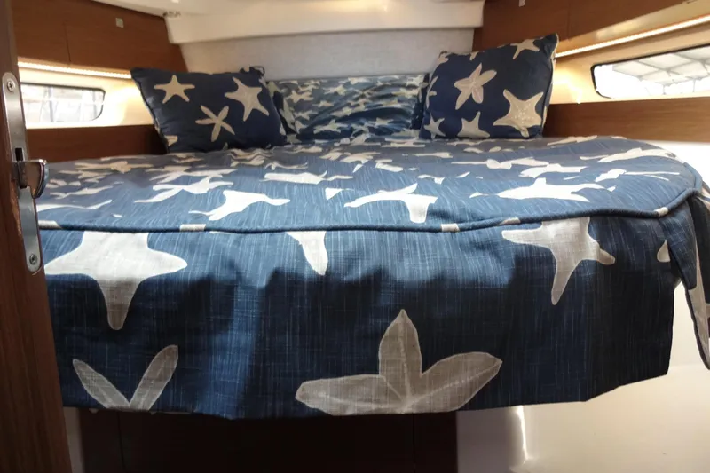 Blue Baby Yacht Photos Pics Cozy cabin interior of 2022 Jeanneau Merry Fisher 895 Offshore with star-patterned bedding.