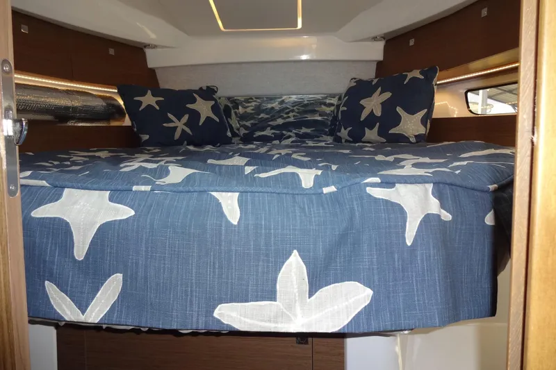 Blue Baby Yacht Photos Pics Cozy cabin interior of 2022 Jeanneau Merry Fisher 895 Offshore with starfish-themed bedding.