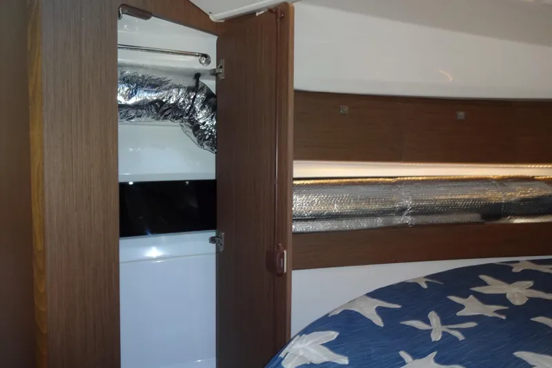 Blue Baby Yacht Photos Pics Interior of 2022 Jeanneau Merry Fisher 895 Offshore with wood finish and star-patterned bedding.