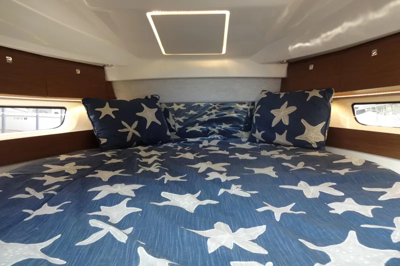 Blue Baby Yacht Photos Pics Cozy cabin interior of 2022 Jeanneau Merry Fisher 895 Offshore with starfish bedding.