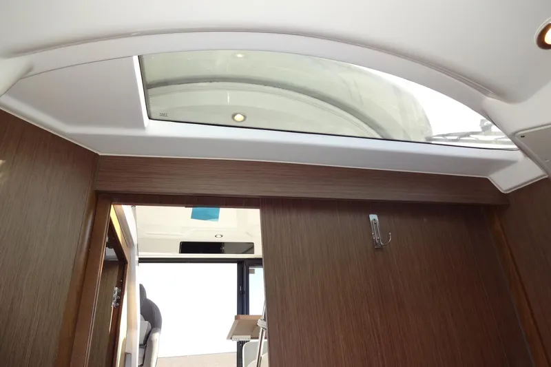 Blue Baby Yacht Photos Pics Interior view of 2022 Jeanneau Merry Fisher 895 Offshore with skylight and wooden finish.