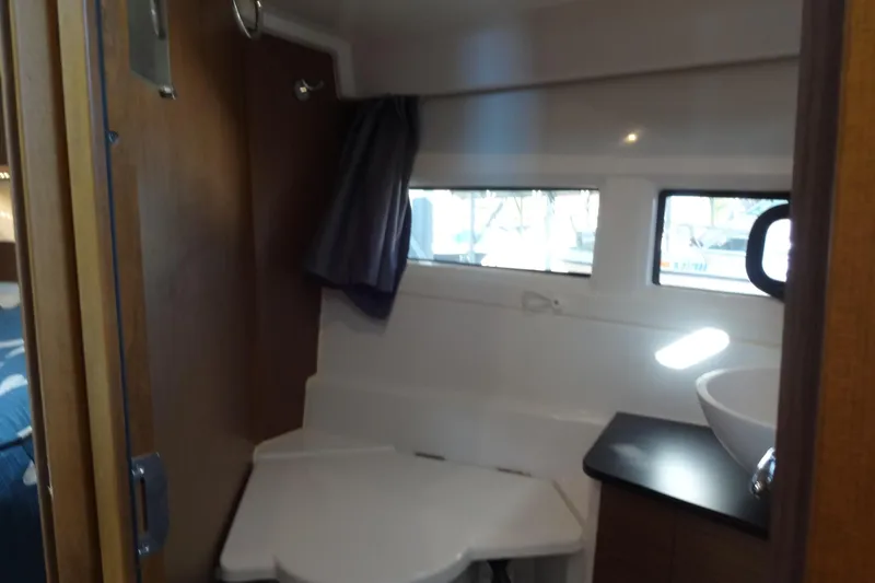 Blue Baby Yacht Photos Pics Interior of 2022 Jeanneau Merry Fisher 895 Offshore boat bathroom with sink and window.