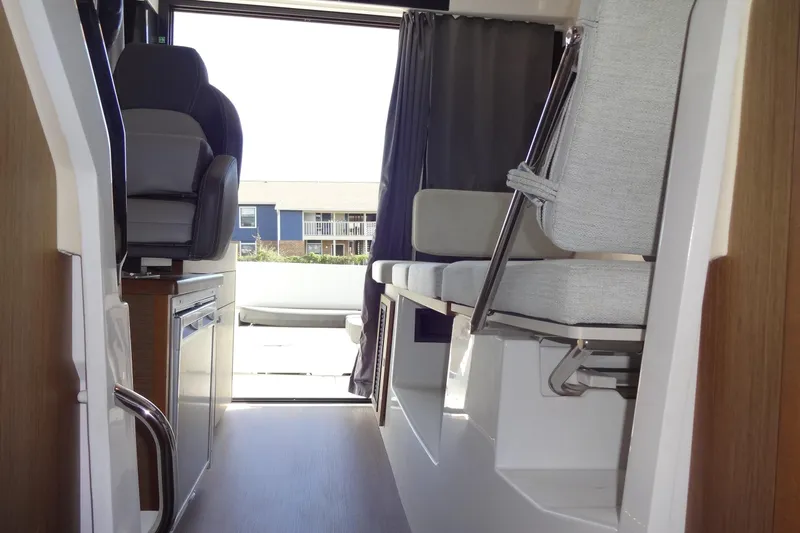 Blue Baby Yacht Photos Pics Interior view of 2022 Jeanneau Merry Fisher 895 Offshore boat, featuring seating and helm area.