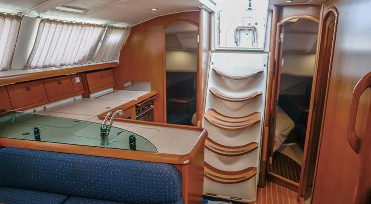 Pelican Yacht Photos Pics Interior of 2002 Jeanneau Sun Odyssey 43 DS yacht, featuring cozy seating and wooden cabinetry.