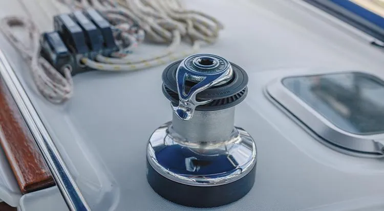 Pelican Yacht Photos Pics Winch on Jeanneau Sun Odyssey 43 DS sailboat deck, 2002 model, with ropes and hatch nearby.