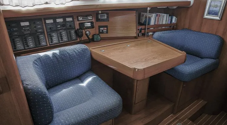Pelican Yacht Photos Pics Cozy interior of 2002 Jeanneau Sun Odyssey 43 DS with navigation station and seating.