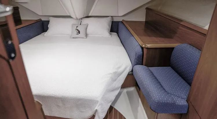 Pelican Yacht Photos Pics Cozy cabin interior of 2002 Jeanneau Sun Odyssey 43 DS with bed and seating area.