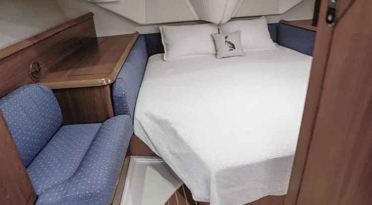 Pelican Yacht Photos Pics Cozy cabin interior of 2002 Jeanneau Sun Odyssey 43 DS sailboat with bed and seating.