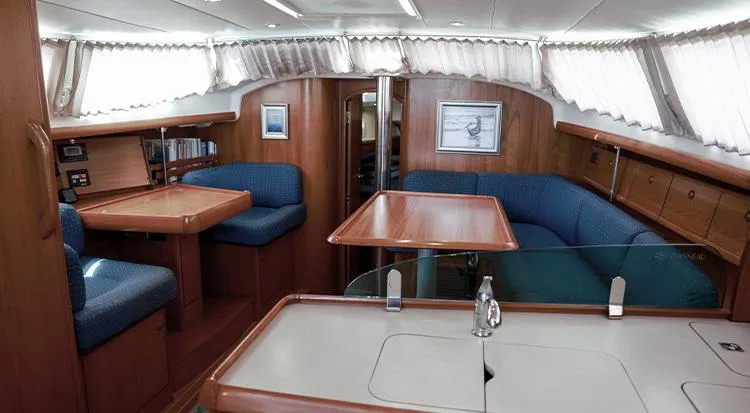 Pelican Yacht Photos Pics Interior of 2002 Jeanneau Sun Odyssey 43 DS sailboat, featuring wood finish and blue seating.