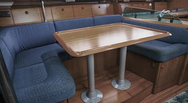 Pelican Yacht Photos Pics Interior of 2002 Jeanneau Sun Odyssey 43 DS with wooden table and blue seating.