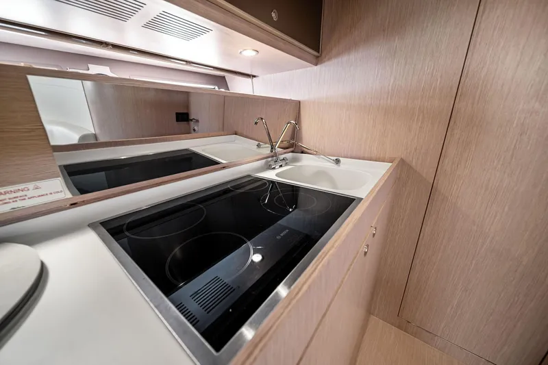 Badleship Yacht Photos Pics Modern kitchen area in a 2015 Riva Rivale yacht with sleek appliances and wood finish.