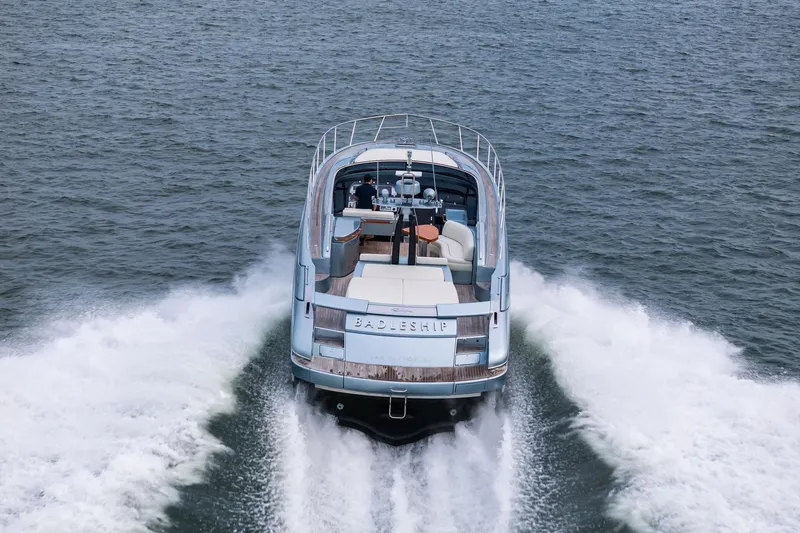 Badleship Yacht Photos Pics 2015 Riva Rivale luxury yacht cruising on open water, rear view.