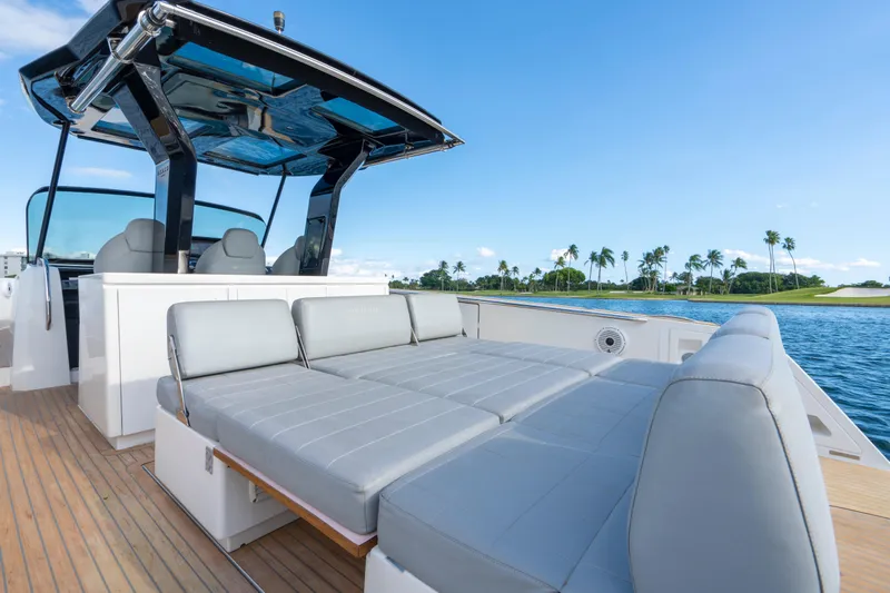  Yacht Photos Pics 2021 Pardo Yachts 38 with luxurious seating, cruising on a sunny day by palm-lined shore.