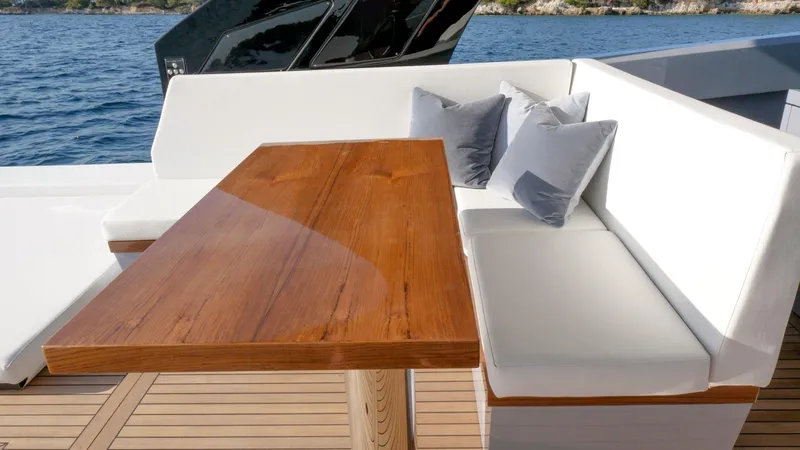 Vespro 55 Yacht Photos Pics Luxurious seating area on Centouno Navi VESPRO 2026 yacht with wooden table and cushions.