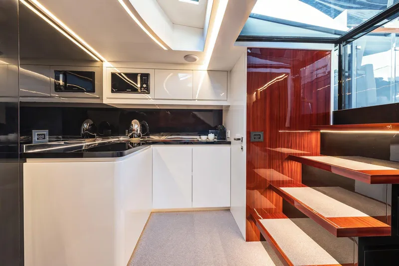 Vespro 55 Yacht Photos Pics Luxurious interior of 2026 Centouno Navi VESPRO yacht with modern kitchen and sleek wooden stairs.