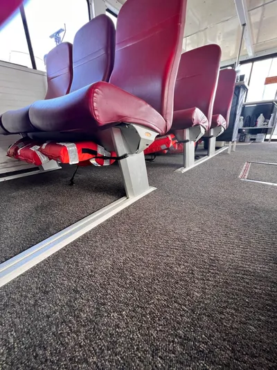 Canyon Odyssey Yacht Photos Pics Interior seating of a 1990 Custom 58 Tour Vessel with red seats and carpeted floor.