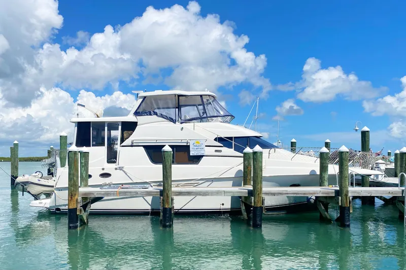 Nauti Boxer Yacht Photos Pics 2003 Silverton 453 Motor Yacht docked under a bright blue sky.
