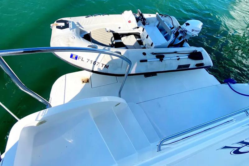 Nauti Boxer Yacht Photos Pics 2003 Silverton 453 Motor Yacht with inflatable dinghy on turquoise water.