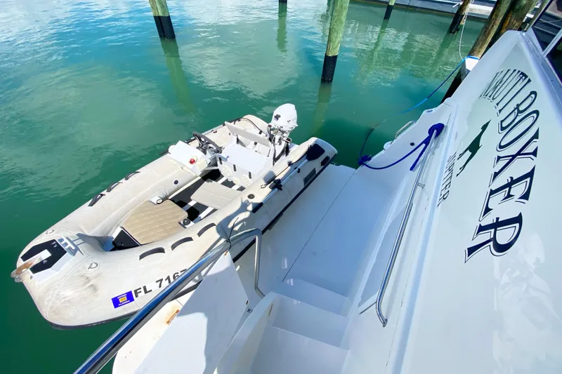 Nauti Boxer Yacht Photos Pics 2003 Silverton 453 Motor Yacht with attached dinghy at dock.