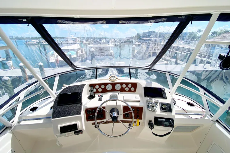 Nauti Boxer Yacht Photos Pics Cockpit view of 2003 Silverton 453 Motor Yacht at marina, showcasing controls and dashboard.