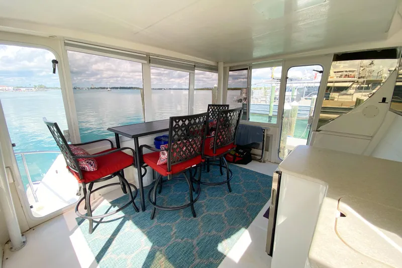 Nauti Boxer Yacht Photos Pics 2003 Silverton 453 Motor Yacht interior with dining area, red cushioned chairs, and waterfront view.