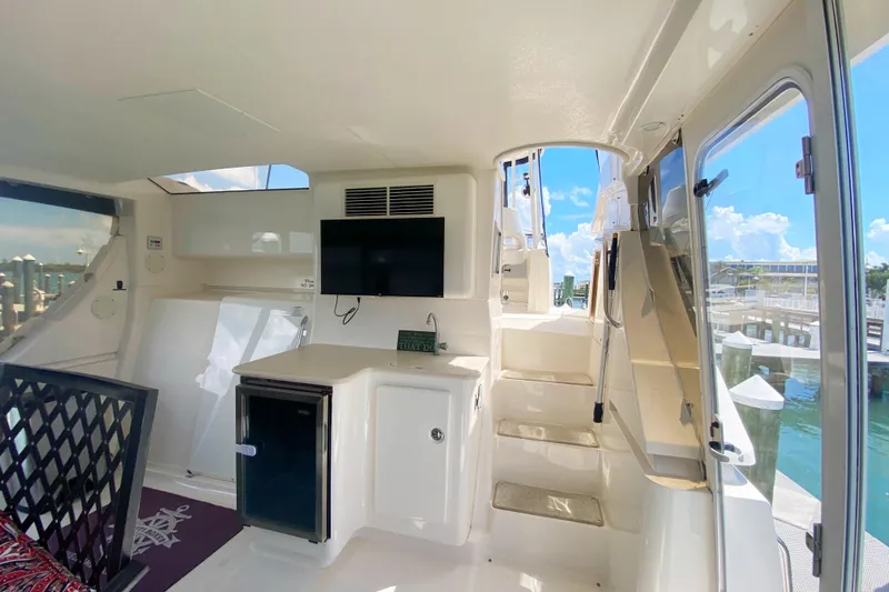 Nauti Boxer Yacht Photos Pics 2003 Silverton 453 Motor Yacht interior with kitchenette and stairs, docked by the water.