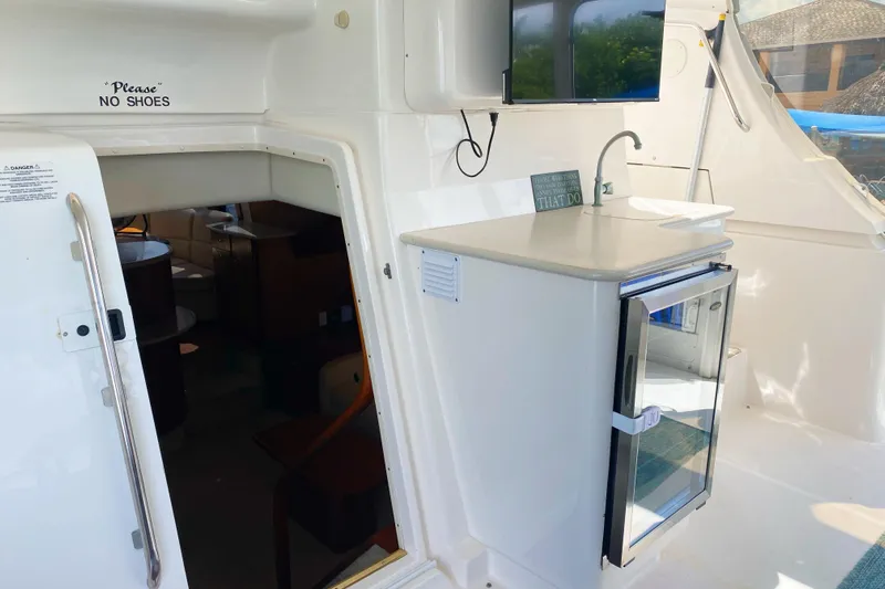 Nauti Boxer Yacht Photos Pics 2003 Silverton 453 Motor Yacht interior with mini fridge and sink, "No Shoes" sign visible.
