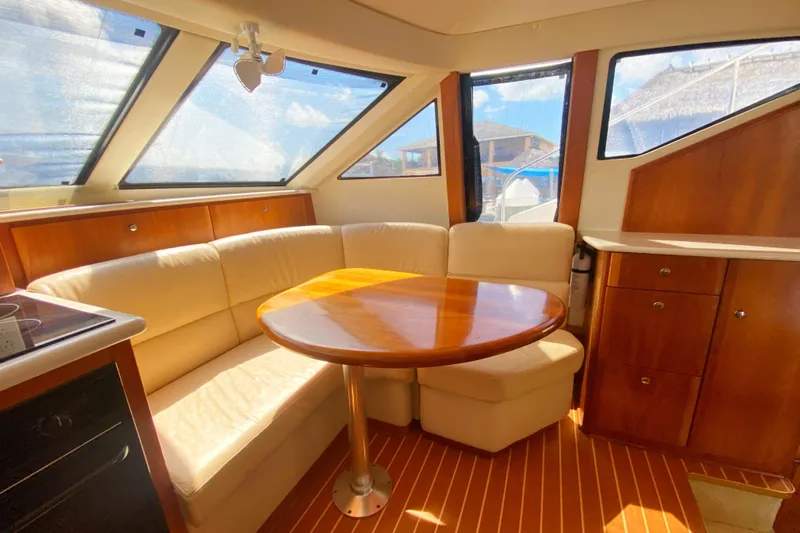 Nauti Boxer Yacht Photos Pics Interior of 2003 Silverton 453 Motor Yacht with cozy seating and wooden table.