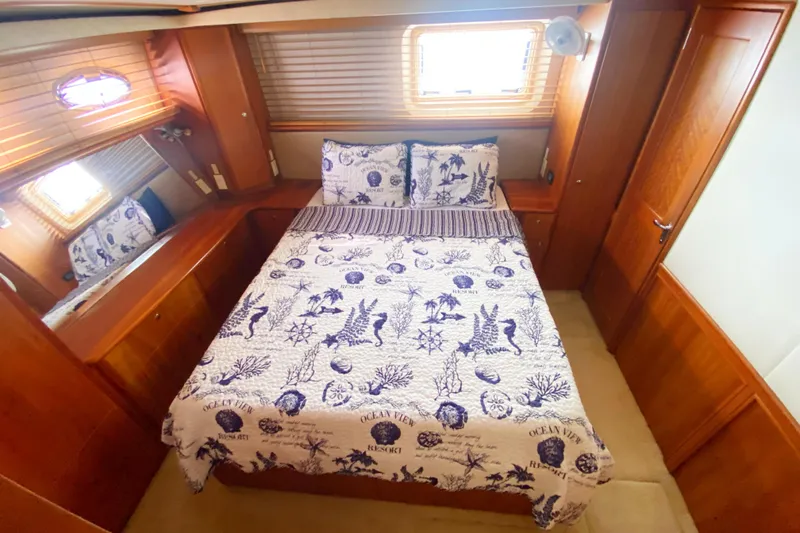 Nauti Boxer Yacht Photos Pics 2003 Silverton 453 Motor Yacht bedroom with nautical-themed bedding and wooden interior.