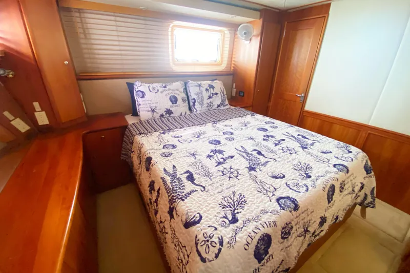 Nauti Boxer Yacht Photos Pics 2003 Silverton 453 Motor Yacht bedroom with nautical-themed bedding and wooden interior.