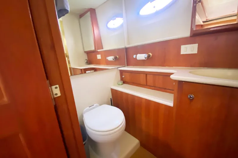 Nauti Boxer Yacht Photos Pics Bathroom interior of 2003 Silverton 453 Motor Yacht with wooden cabinetry and oval windows.
