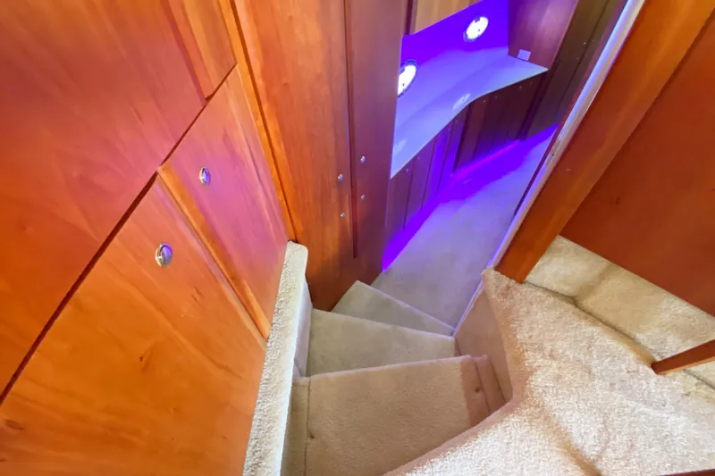 Nauti Boxer Yacht Photos Pics Staircase inside 2003 Silverton 453 Motor Yacht with wooden paneling and purple lighting.