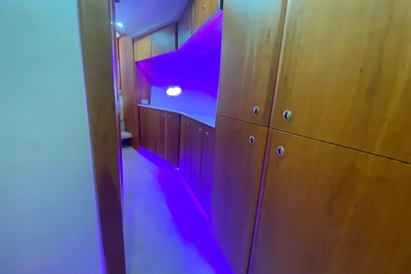 Nauti Boxer Yacht Photos Pics Interior hallway of 2003 Silverton 453 Motor Yacht with wooden cabinets and purple lighting.