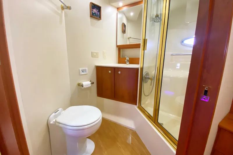 Nauti Boxer Yacht Photos Pics 2003 Silverton 453 Motor Yacht bathroom with shower, toilet, and wooden cabinetry.