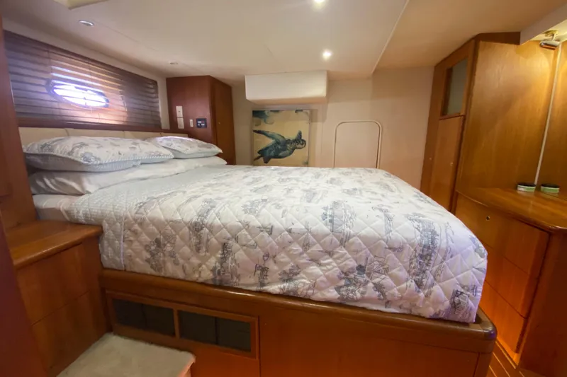Nauti Boxer Yacht Photos Pics Luxurious bedroom in 2003 Silverton 453 Motor Yacht with cozy bedding and wooden cabinetry.