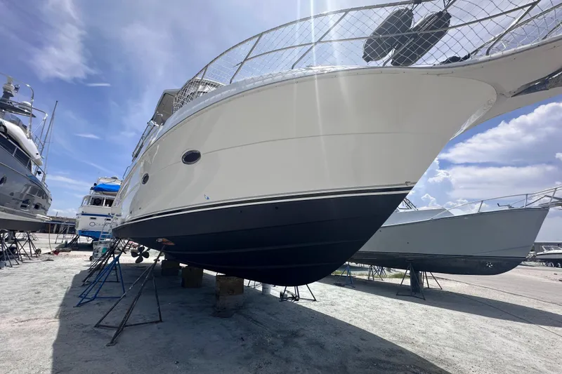 Nauti Boxer Yacht Photos Pics 2003 Silverton 453 Motor Yacht on dry dock under clear blue sky.