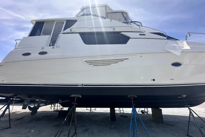 Nauti Boxer Yacht Photos Pics 2003 Silverton 453 Motor Yacht on stands, viewed from below, under a clear blue sky.