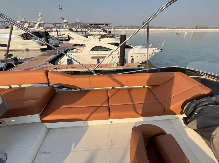  Yacht Photos Pics 2011 Marquis 500 Sport Bridge yacht with brown seating at marina.