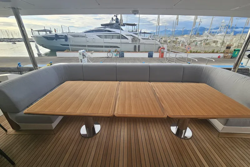 Dream Yacht Photos Pics Luxurious 2024 Azimut Grande 32 Metri yacht with elegant outdoor seating and wooden tables.
